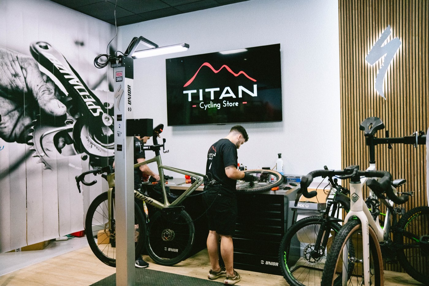 Mecánico reparando una bicicleta en TITAN Cycling Store, taller asociado a Bikiot